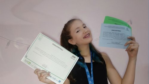 Karol com medalhas e certificados.